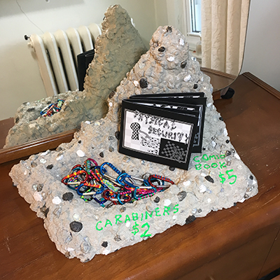 Comic book and carabiners on concrete stand